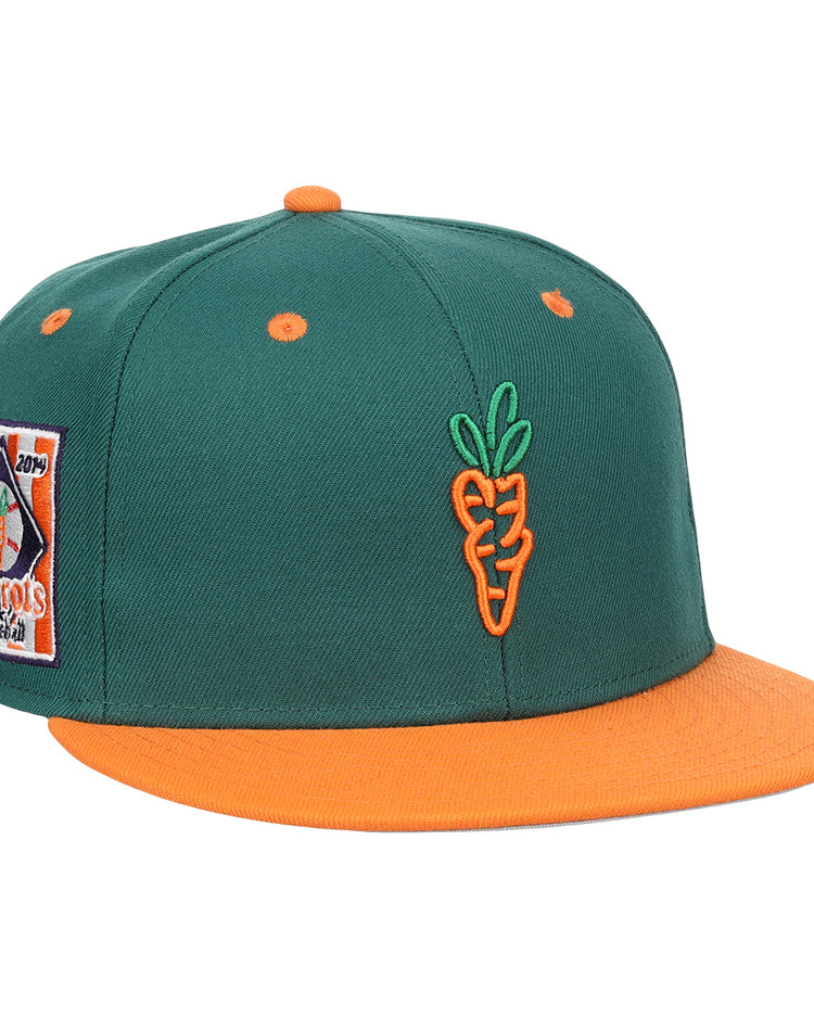 The EFF Carrots Arlington Heights Collection Logo Fitted Ballcap features green fabric, an orange brim and button, an embroidered orange carrot on the front, and a colorful side patch in the classic Ebbets Field Flannels style.