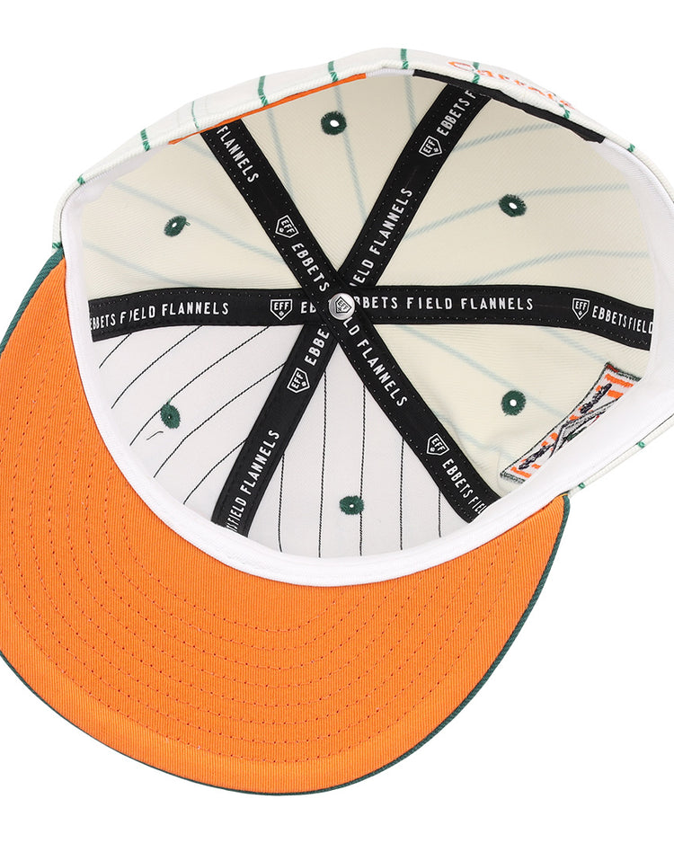 Interior view of the Carrots Arlington Heights Collection Pinstripe Fitted Ballcap by EFF, featuring orange brim stitching, green stripes and vents, plus black bands with the “EBBETS FIELD FLANNELS” logo from a brand collaboration.