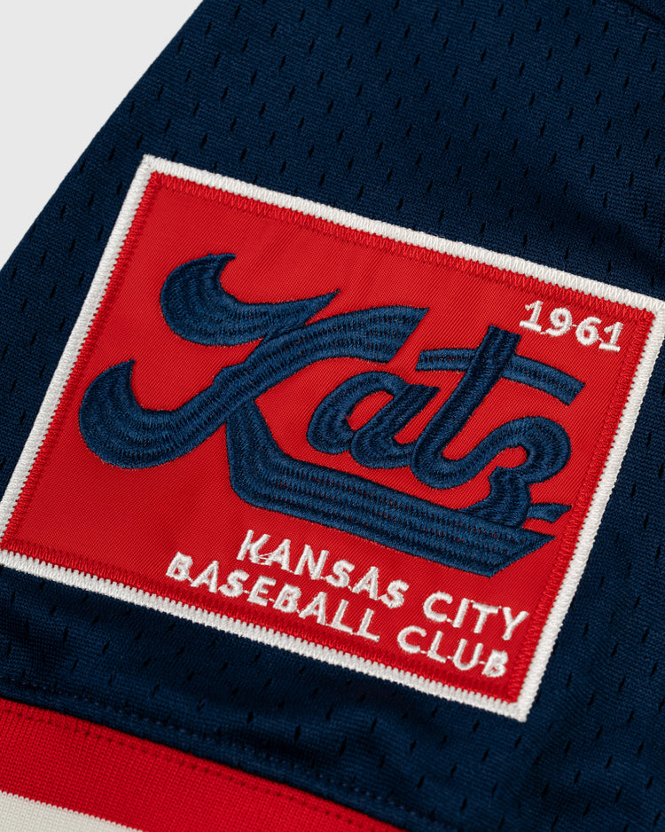 A close-up of the EFF Kansas City Katz Mesh V-Neck Jersey shows a Kansas City Katz patch honoring Katz Drugstore, with Katz in blue script and 1961 in red on a red, white, and blue background sewn to dark blue mesh fabric.