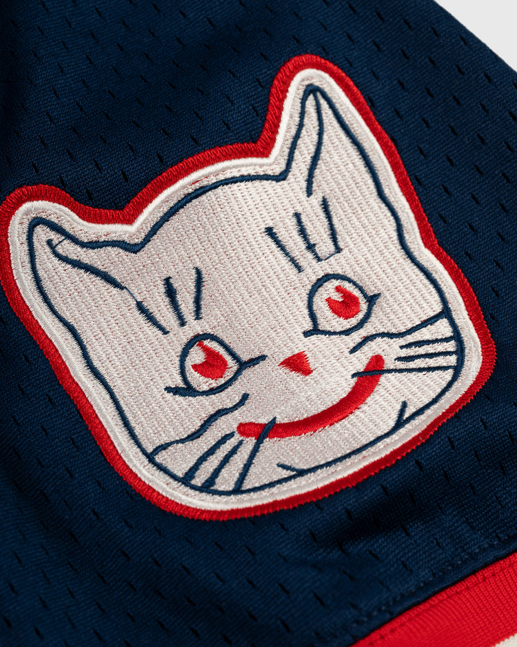 Close-up of an EFF Kansas City Katz Mesh V-Neck Jersey, featuring a cartoon-style white cat with red eyes and accents outlined in red, sewn onto navy blue mesh—an homage to the iconic Katz Drugstore.