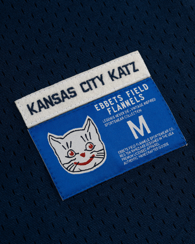 The EFF Kansas City Katz Mesh V-Neck Jersey features blue and white colors, a cartoon cat face, and honors Katz Drugstore’s Ban Johnson Baseball League legacy.