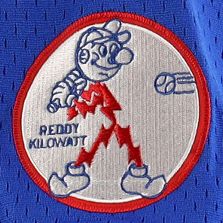 The Reddy Kilowatt EFF DNA Replica V-Neck Mesh Jersey by EFF features Reddy Kilowatt, the red lightning bolt cartoon, with a baseball bat and Reddy Kilowatt text as a ball flies in on a blue mesh-textured electric power background.