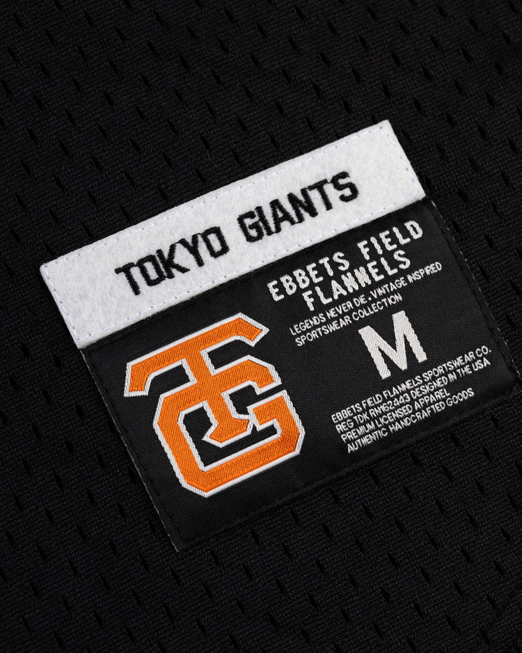 A close-up of the Tokyo Giants Mesh V-Neck Baseball Jersey by EFF, featuring two stitched labels: one with Tokyo Giants and another with an orange TG logo, size M, plus EFF sportswear details.