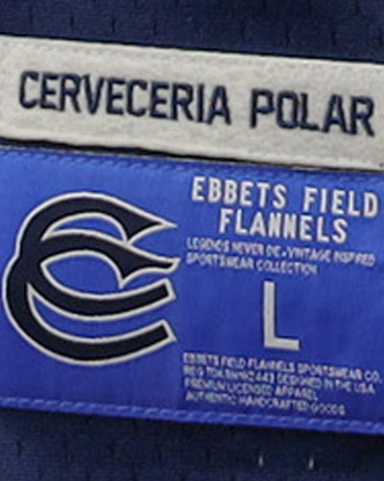 A close-up of two labels on the Cerveceria Polar EFF DNA Replica V-Neck Mesh Jersey by EFF: the top says CERVECERIA POLAR, and the blue label features a C logo, EFFETS FIELD FLANNELS branding, size L, and manufacturing info.