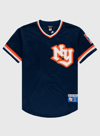 The EFF New York Knights Mesh V-Neck Jersey features a navy blue design with orange and white trim, a large “NY” logo, sleeve patch, and “New York Forever” label—modeled after Robert Redford’s jersey in The Natural.