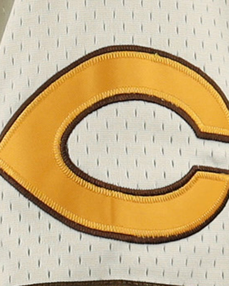A yellow letter C with a brown outline is sewn onto a light mesh fabric, featured on the Cordoba Cafeteros EFF DNA Replica Button-Up Mesh Jersey by EFF, celebrating Mexican baseball heritage.