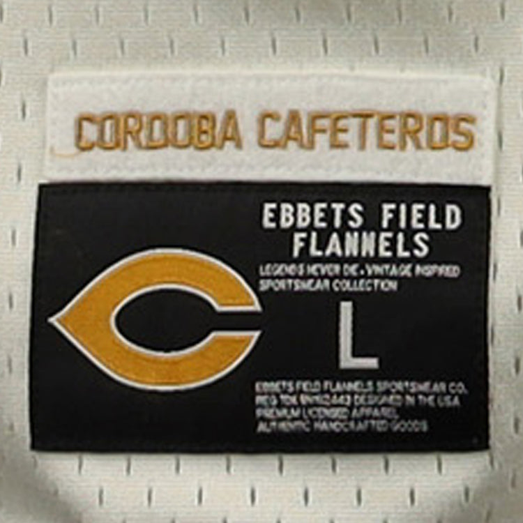 The EFF Cordoba Cafeteros EFF DNA Replica Button-Up Mesh Jersey features a gold CORDOBA CAFETEROS label on white, inspired by Mexican pro baseball, and a patch with a yellow C, “EBBETS FIELD FLANNELS,” size L, and product info in white on black.