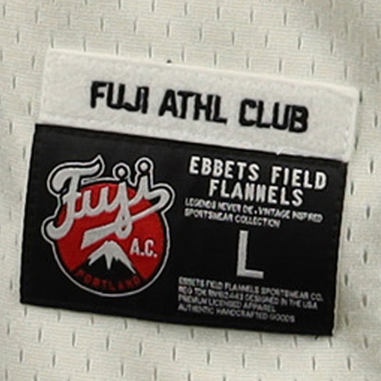 A close-up of the label on the Fuji Athletic Club EFF DNA Replica Button-Up Mesh Jersey by EFF, featuring the red and white Fuji logo inspired by Portland Fuji and Japanese baseball heritage. Label shows size L.