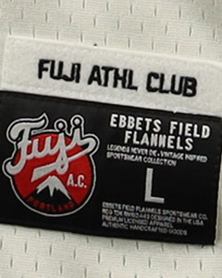 A close-up of the label on the Fuji Athletic Club EFF DNA Replica Button-Up Mesh Jersey by EFF, featuring the red and white Fuji logo inspired by Portland Fuji and Japanese baseball heritage. Label shows size L.