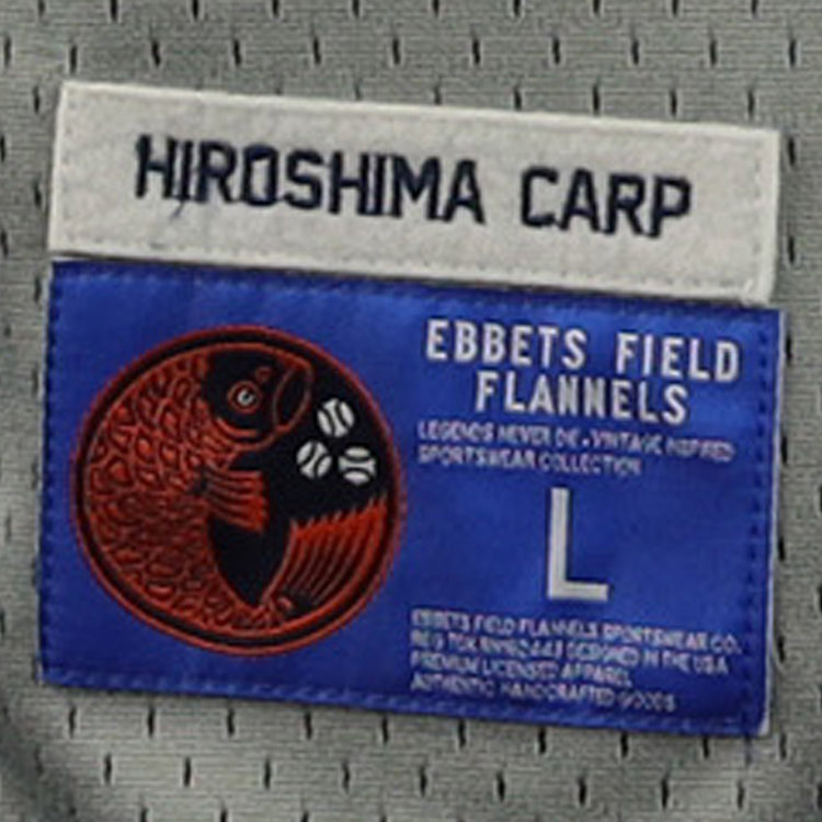 Clothing tag for the Hiroshima Carp EFF DNA Replica Button-Up Mesh Jersey by EFF, featuring “HIROSHIMA CARP” on a white label above a blue label with a red koi fish graphic, size L, and manufacturer info.