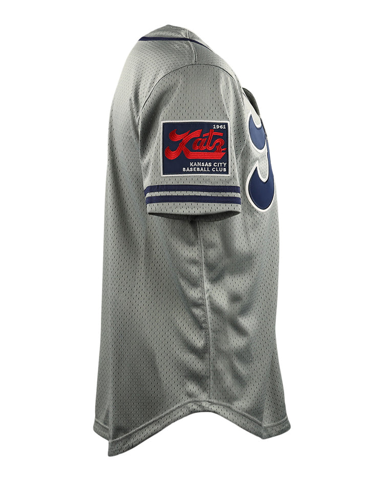 Side view of the Kansas City Katz EFF DNA Replica Button-Up Mesh Jersey by EFF, featuring a gray design, red and black patch on the sleeve, bold blue numbers on the front, and honoring the Ban Johnson Baseball League.