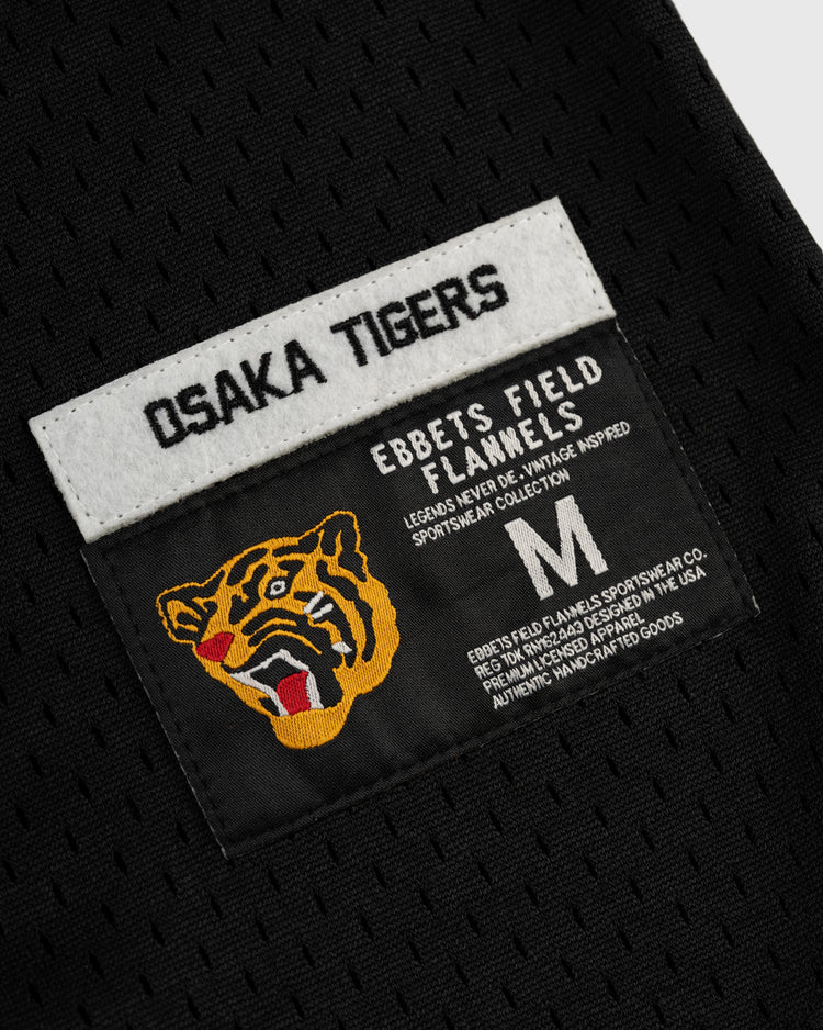 A black Osaka Tigers Mesh Button-Up Baseball Jersey by EFF features two labels: one with the team name and another with a tiger head, brand logo, sizing, and sportswear collection details in white and yellow.