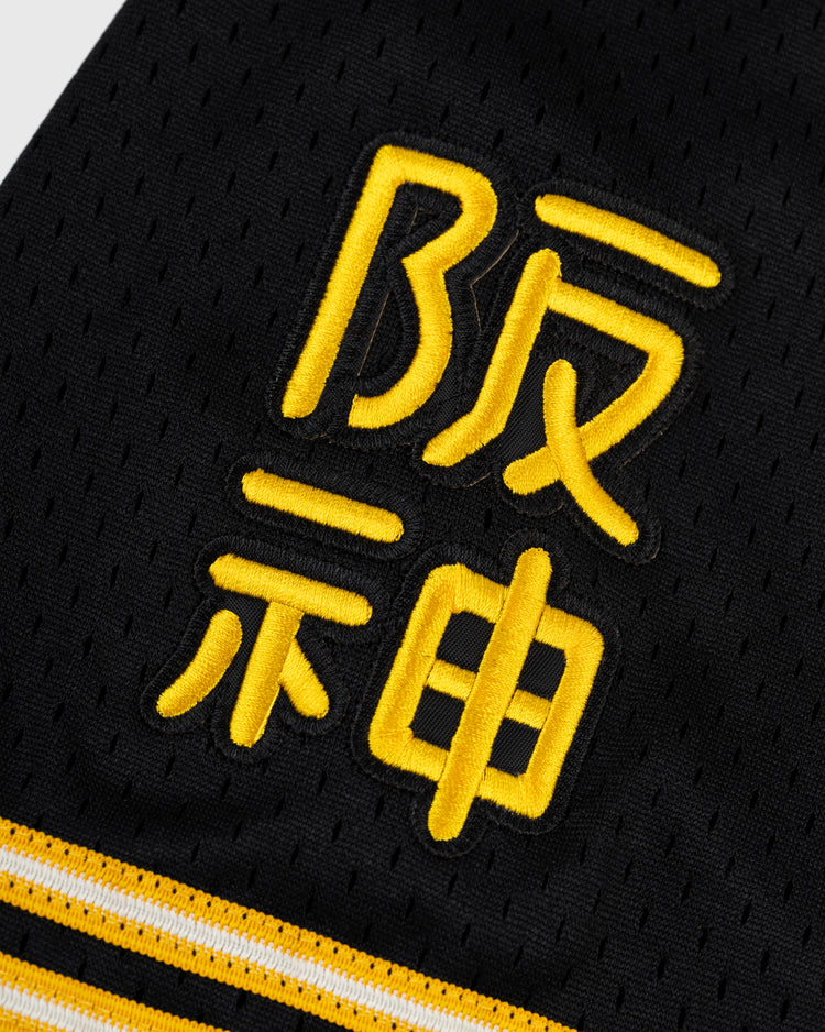 Close-up of black mesh fabric featuring yellow Japanese embroidery and yellow-white stripes, inspired by the legendary Osaka Tigers. Shown here: the EFF Osaka Tigers Mesh Button-Up Baseball Jersey.