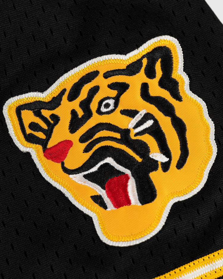 A close-up of the yellow and black tiger head logo with red and white accents, embroidered on black mesh fabric from the EFF Osaka Tigers Mesh Button-Up Baseball Jersey.