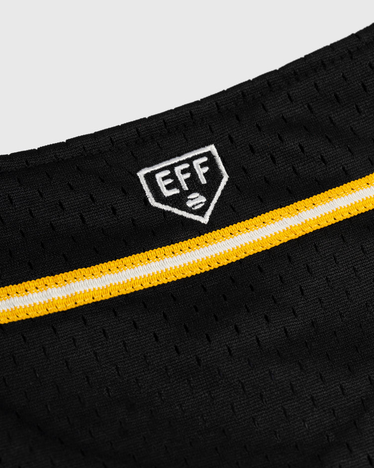 Close-up of a black mesh Osaka Tigers Mesh Button-Up Baseball Jersey by EFF, featuring an embroidered white EFF shield logo above a yellow and white striped band inspired by the legendary Japanese baseball franchises Koshien Field style.