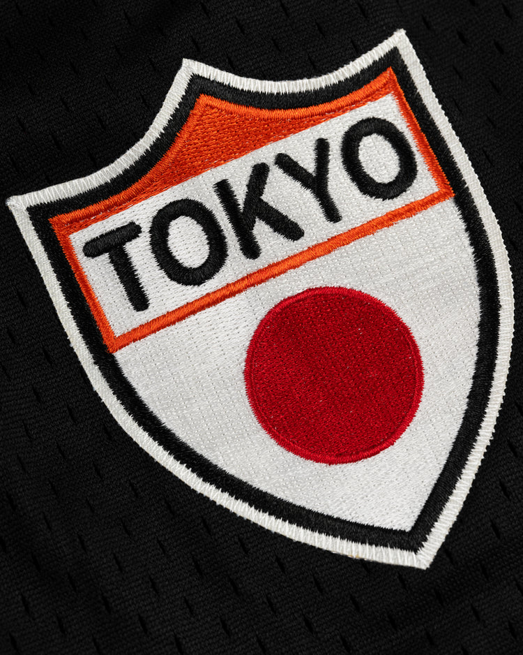 The EFF Tokyo Giants Mesh Button-Up Jersey features a vintage-style patch with “TOKYO” in black above a red circle on a white and orange shield, set against black fabric—ideal for mesh jersey collectors and Tokyo Giants fans.