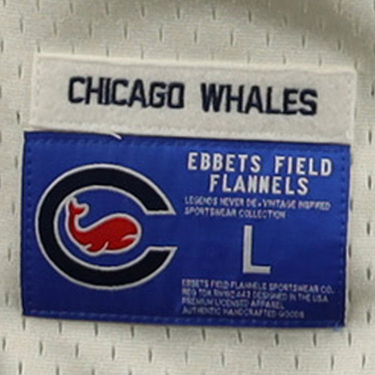 A label for the EFF Chicago Whales DNA Replica Button-Up Mesh Jersey features CHICAGO WHALES on top, a blue patch with a red whale inside a C—honoring the Federal League team—and text: EBBETS FIELD FLANNELS, size L.