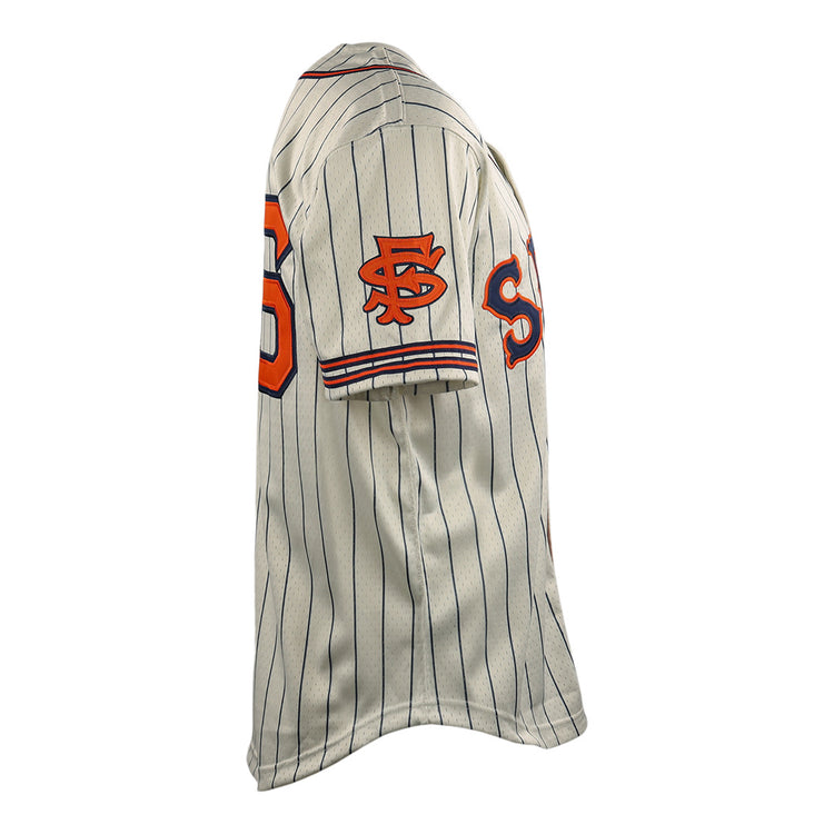 The EFF San Francisco Seals DNA Replica Button-Up Mesh Jersey features cream fabric with vertical navy pinstripes and orange and black logos and numbers on the sleeve and chest, shown from a side angle.