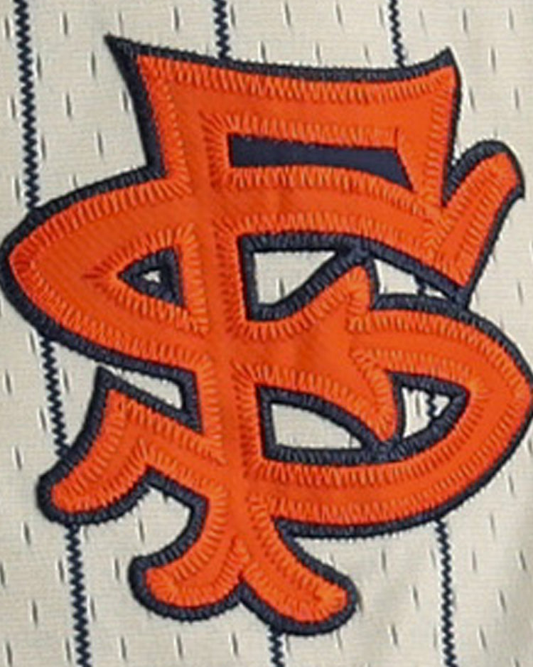 Orange, intertwined SF letters outlined in black are stitched onto white pinstriped mesh, echoing the classic San Francisco Seals logo on the EFF San Francisco Seals DNA Replica Button-Up Mesh Jersey—perfect for vintage style.