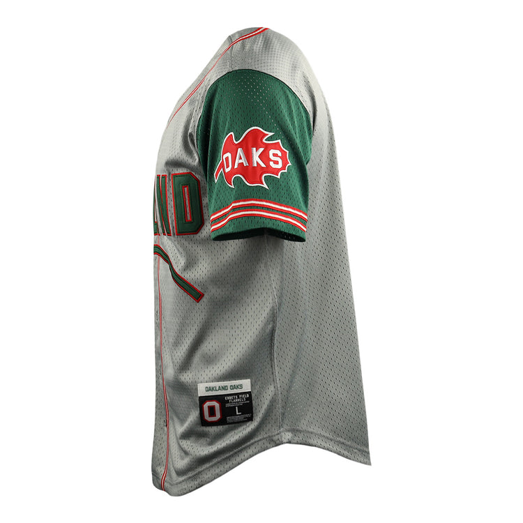Side view of the Oakland Oaks EFF DNA Replica Button-Up Mesh Jersey by EFF: gray with green sleeves, red/green trim, OAKS in red text on a leaf on the sleeve, and a label near the hem reading OAKLAND OAKS with size info.