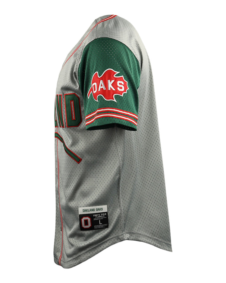 Side view of the Oakland Oaks EFF DNA Replica Button-Up Mesh Jersey by EFF: gray with green sleeves, red/green trim, OAKS in red text on a leaf on the sleeve, and a label near the hem reading OAKLAND OAKS with size info.