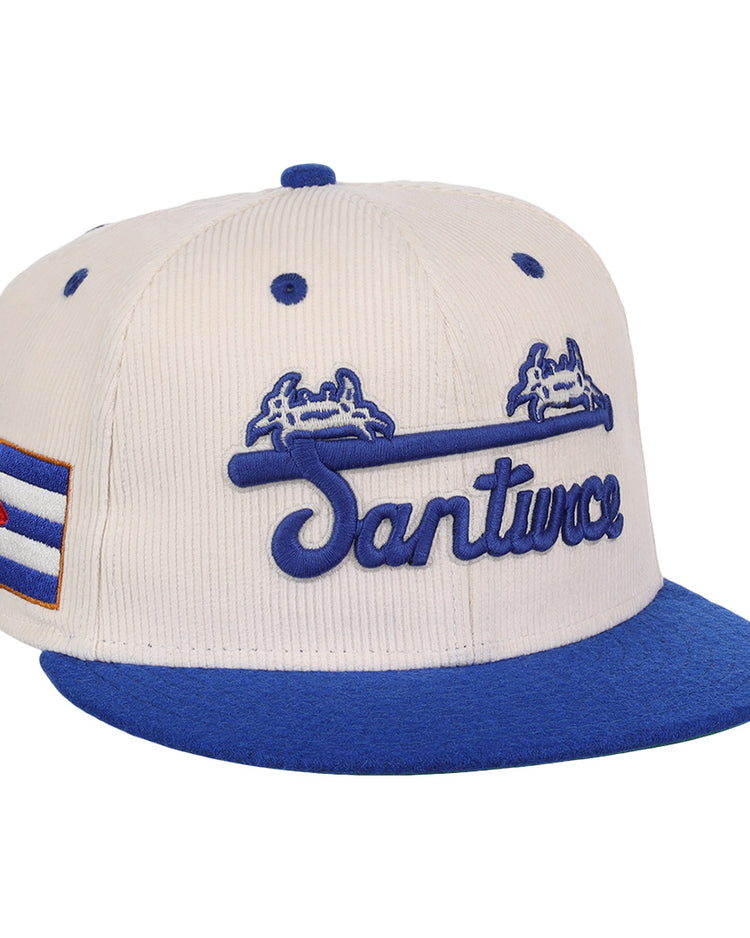 The EFF Santurce Cangrejeros NLB Ground Rule Double Fitted Ballcap is a vintage-inspired cream and blue cap with Santurce in blue script, two crabs above, and the Cuban flag on the side.