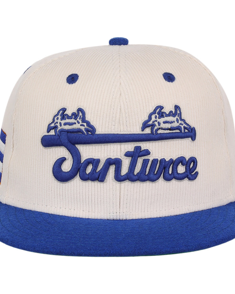 The EFF Santurce Cangrejeros NLB Ground Rule Double Fitted Ballcap features a beige crown, blue brim, Santurce script, blue crab graphics above a bat, and side stripes—ideal for Puerto Rican League fans.