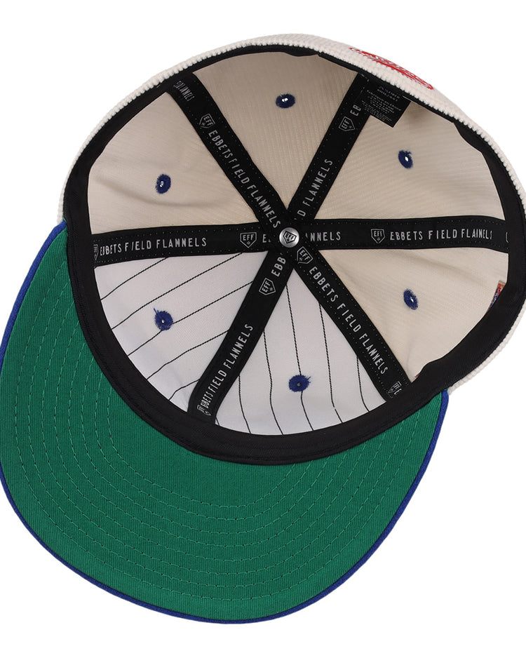 The image shows the inside of an EFF Santurce Cangrejeros NLB Ground Rule Double Fitted Ballcap, featuring pinstripe lining, blue stitching, blue rivets, a green underbrim, black EBBETS FIELD FLANNELS taping, and a vintage-inspired design.