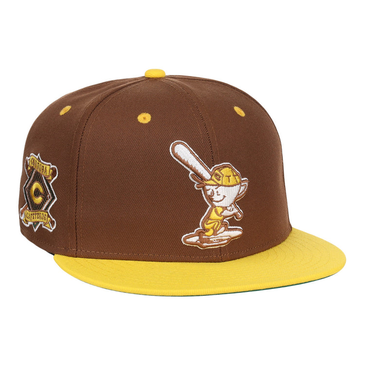 The EFF Cordoba Cafeteros DNA Fitted Ballcap is a vintage-inspired brown cap with a yellow brim, featuring a cartoon baseball character on the front and a yellow-brown side patch, echoing classic Ebbets Field Flannels style.