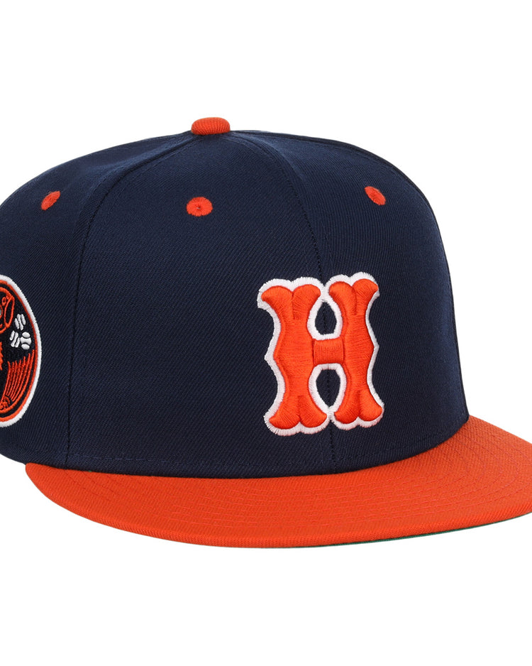 The EFF Hiroshima Carp EFF DNA Fitted Ballcap features navy blue with an orange brim, button, and eyelets, a bold orange and white H on the front in Carp style, and a circular side patch. Inspired by vintage Ebbets Field Flannels.