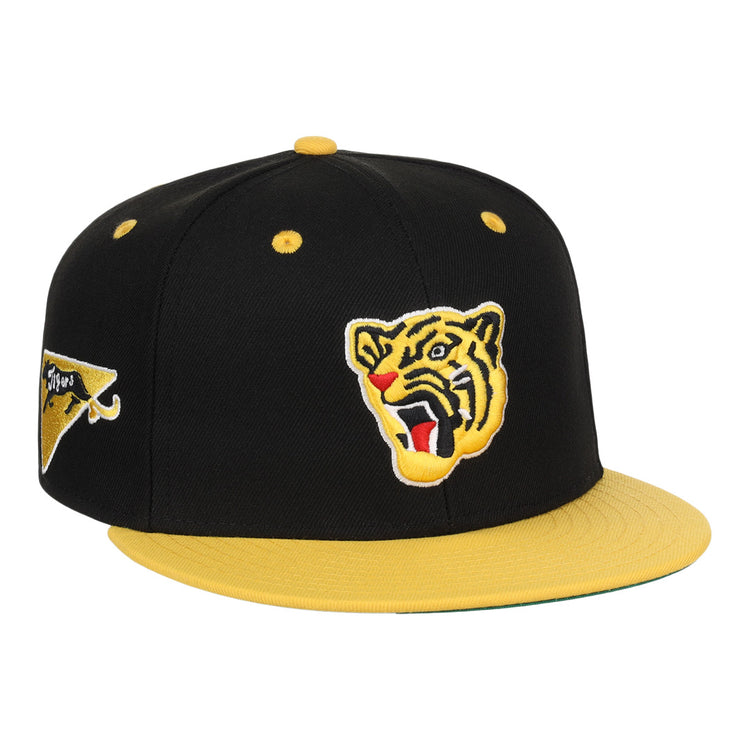 The EFF Osaka Tigers EFF DNA Fitted Ballcap features a black and yellow vintage look with a yellow brim, an embroidered roaring tiger face on the front, and a triangular logo on the side, inspired by classic Japanese baseball style.