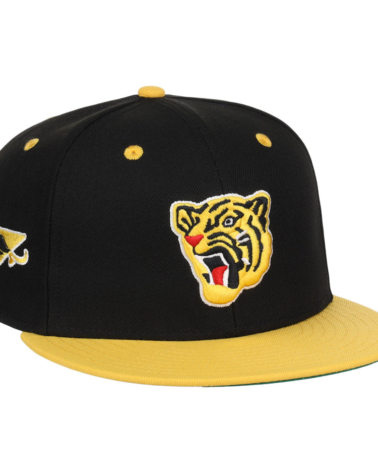The EFF Osaka Tigers EFF DNA Fitted Ballcap features a black and yellow vintage look with a yellow brim, an embroidered roaring tiger face on the front, and a triangular logo on the side, inspired by classic Japanese baseball style.