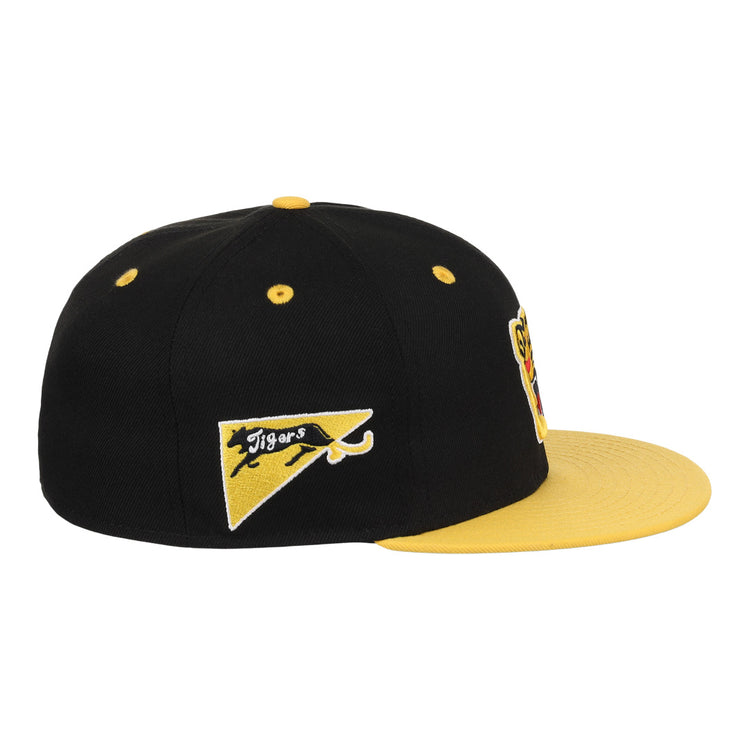The EFF Osaka Tigers EFF DNA Fitted Ballcap is a black and yellow vintage cap with a yellow brim, button, and side pennant patch featuring a black panther and Tigers, inspired by Japanese baseball. Additional patches are partially visible front.