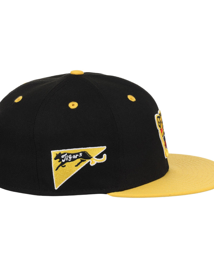 The EFF Osaka Tigers EFF DNA Fitted Ballcap is a black and yellow vintage cap with a yellow brim, button, and side pennant patch featuring a black panther and Tigers, inspired by Japanese baseball. Additional patches are partially visible front.