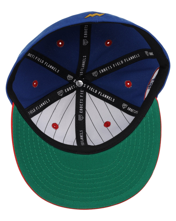 The Reddy Kilowatt EFF DNA Fitted Ballcap by EFF features a blue crown, green undervisor, red trim, black Ebbets Field Flannels branding inside, and a white pinstriped lining with red stitching.
