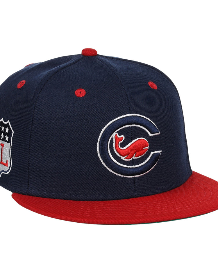 The EFF Chicago Whales EFF DNA Fitted Ballcap is a vintage-inspired navy cap with a red brim, stylized “C” and Whales logo on the front, plus an “FL” shield patch on the side.