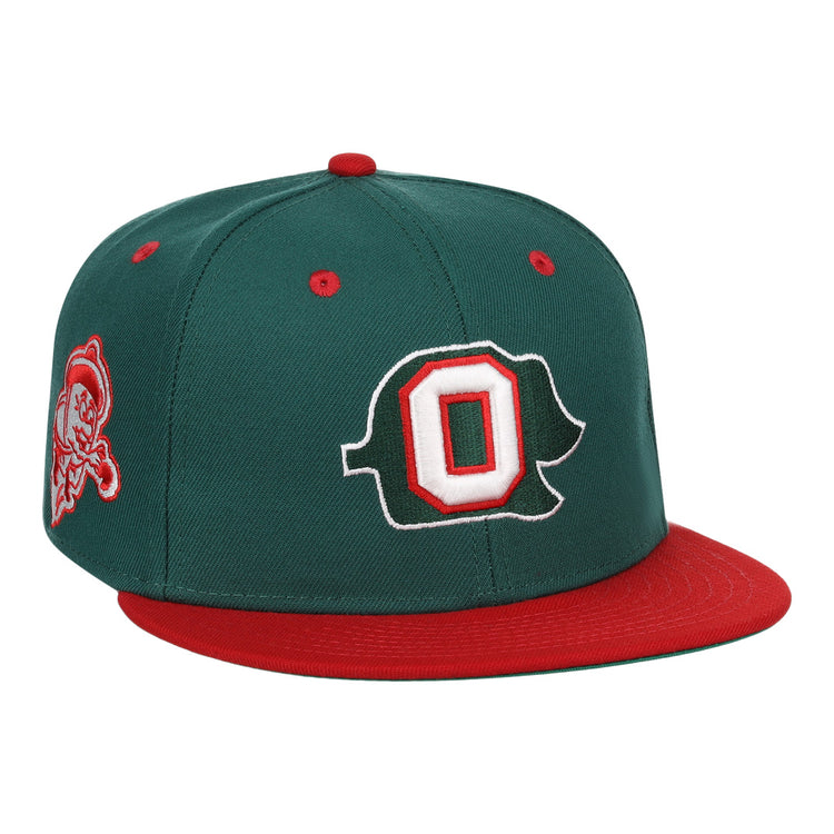 The Oakland Oaks EFF DNA Fitted Ballcap by EFF is a vintage-inspired dark green cap with a red brim/button, featuring a large white/red outlined O on the front and a pirate mascot patch on the side.