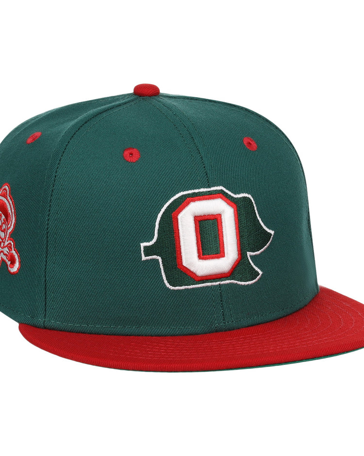 The Oakland Oaks EFF DNA Fitted Ballcap by EFF is a vintage-inspired dark green cap with a red brim/button, featuring a large white/red outlined O on the front and a pirate mascot patch on the side.