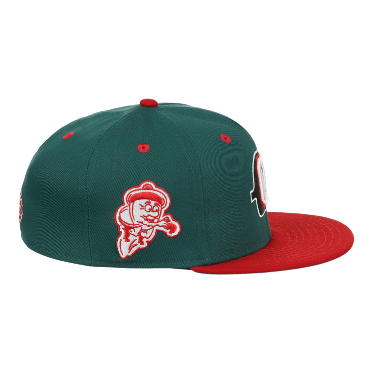 The Oakland Oaks EFF DNA Fitted Ballcap by EFF is a vintage-inspired green fitted cap with a red brim, cartoon ghost patch on the side, ventilation holes on top, and classic Ebbets Field Flannels style.