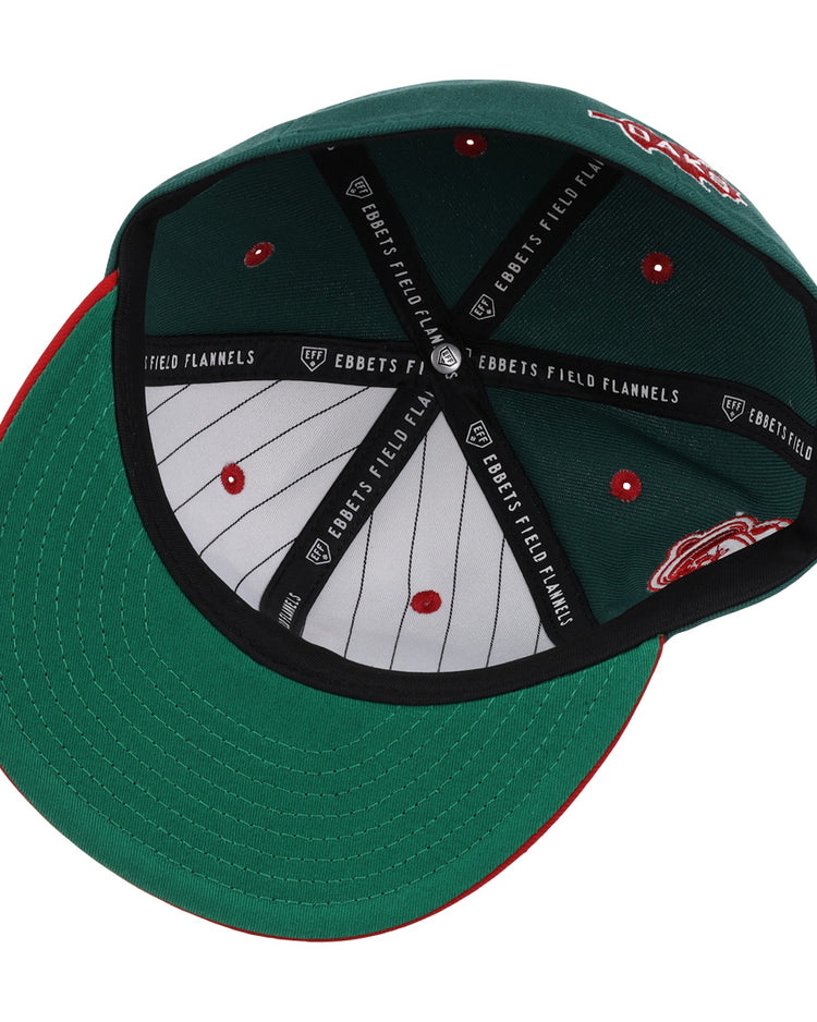The Oakland Oaks EFF DNA Fitted Ballcap by EFF is shown upside down, highlighting its inner lining with Ebbets Field Flannels branding and red stitched details on the inside panels.