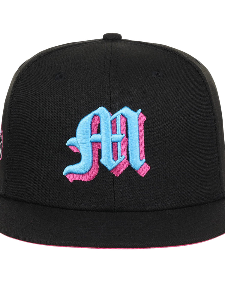The EFF Miami Giants NLB Team Color Fitted Ballcap is a vintage-inspired black cap with a large blue Old English M outlined in pink and an embroidered team logo on the front.