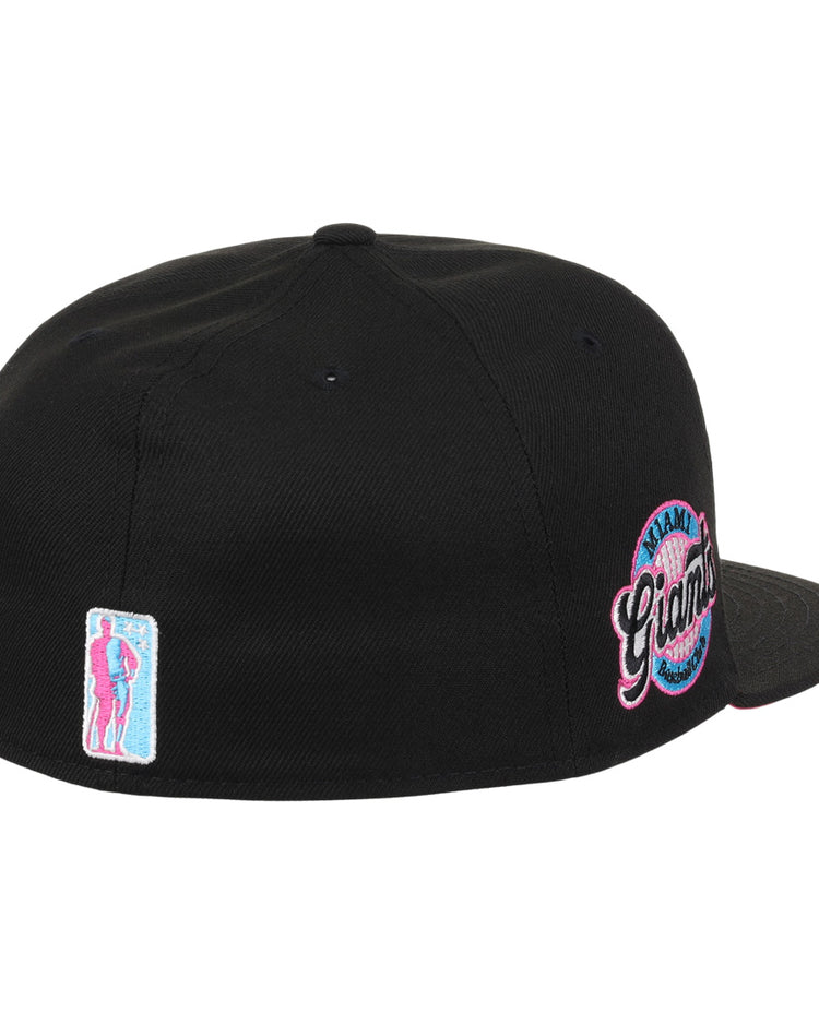 The EFF Miami Giants NLB Team Color Fitted Ballcap in black features a back view, an embroidered team logo patch, and a small pink and blue figure patch on the left, honoring this historic Black barnstorming team.