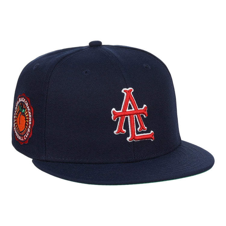 The EFF Atlanta Black Crackers NLB Team Color Fitted Ballcap is a vintage-inspired navy hat featuring a bold red and white logo on the front and an orange-and-black round patch on the side.