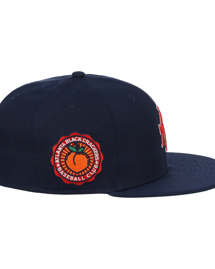 The EFF Atlanta Black Crackers NLB Team Color Fitted Ballcap in navy features a red and orange side patch reading Atlanta Black Crackers Baseball Club around an orange baseball, inspired by classic Negro Southern League styles.