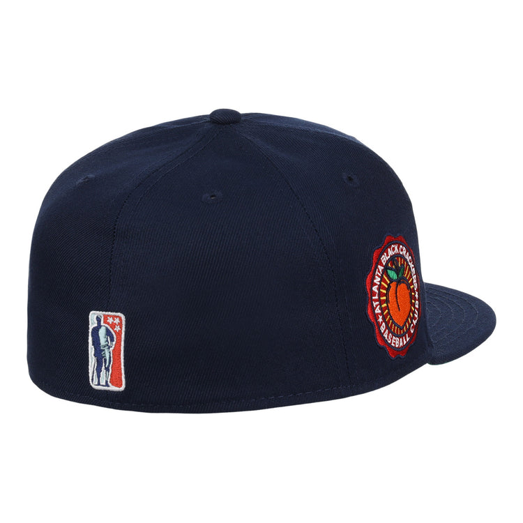 The EFF Atlanta Black Crackers NLB Team Color Fitted Ballcap is a vintage-inspired navy hat with a round orange and green side patch and a small man-with-bat embroidered logo on the back.