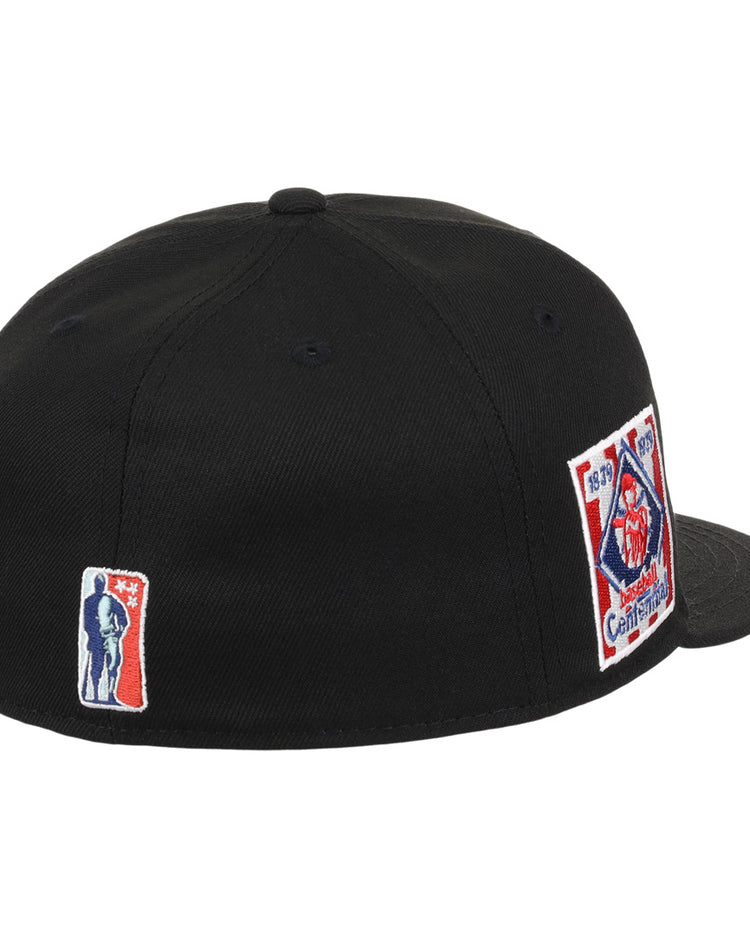 The EFF Philadelphia Stars NLB Team Color Fitted Ballcap is a black cap featuring a rectangular fire department emblem patch with red, white, and blue details on the side and an embroidered Star logo patch on the back.