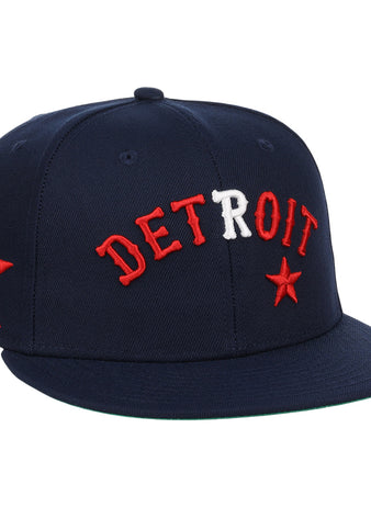 The EFF Detroit Stars NLB Team Color Fitted Ballcap is a vintage-inspired navy cap with DETROIT embroidered in red and white, red stars on the front and side, and a flat brim.