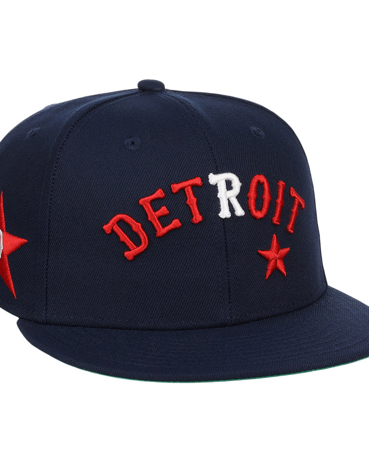 The EFF Detroit Stars NLB Team Color Fitted Ballcap is a vintage-inspired navy cap with DETROIT embroidered in red and white, red stars on the front and side, and a flat brim.