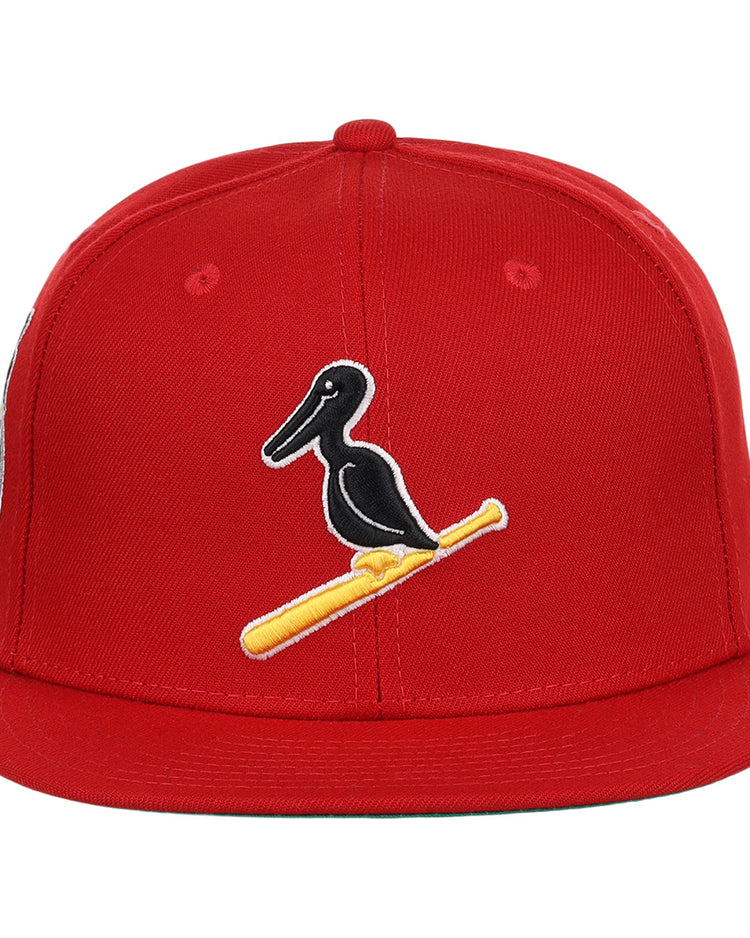 The EFF New Orleans Black Pelicans NLB Team Color Fitted Ballcap in red features an embroidered black pelican on a yellow bat, honoring the historic Negro Southern League team.