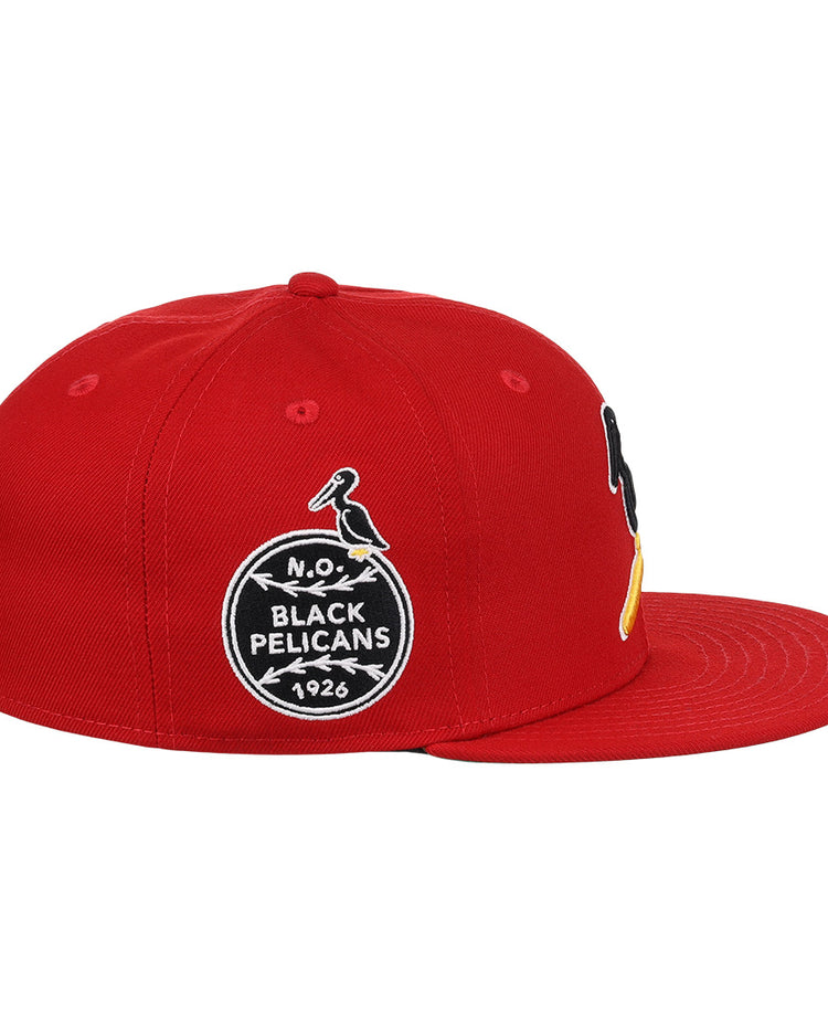 The EFF New Orleans Black Pelicans NLB Team Color Fitted Ballcap in red features embroidered patches, including a circular 1926 Negro Southern League logo with a black-and-yellow pelican on the front.